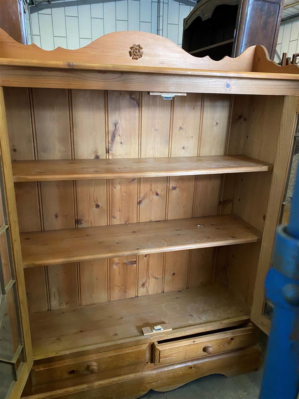 A glazed pine two door bookcase, width 112cm, depth 26cm, height 150cm